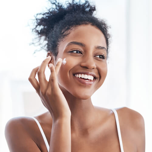 Woman applying moisturizer